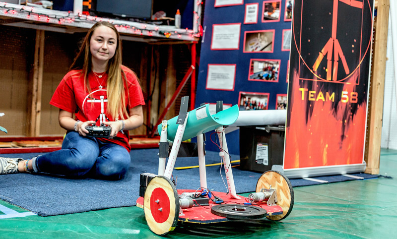 Photo of a student operating a robot.