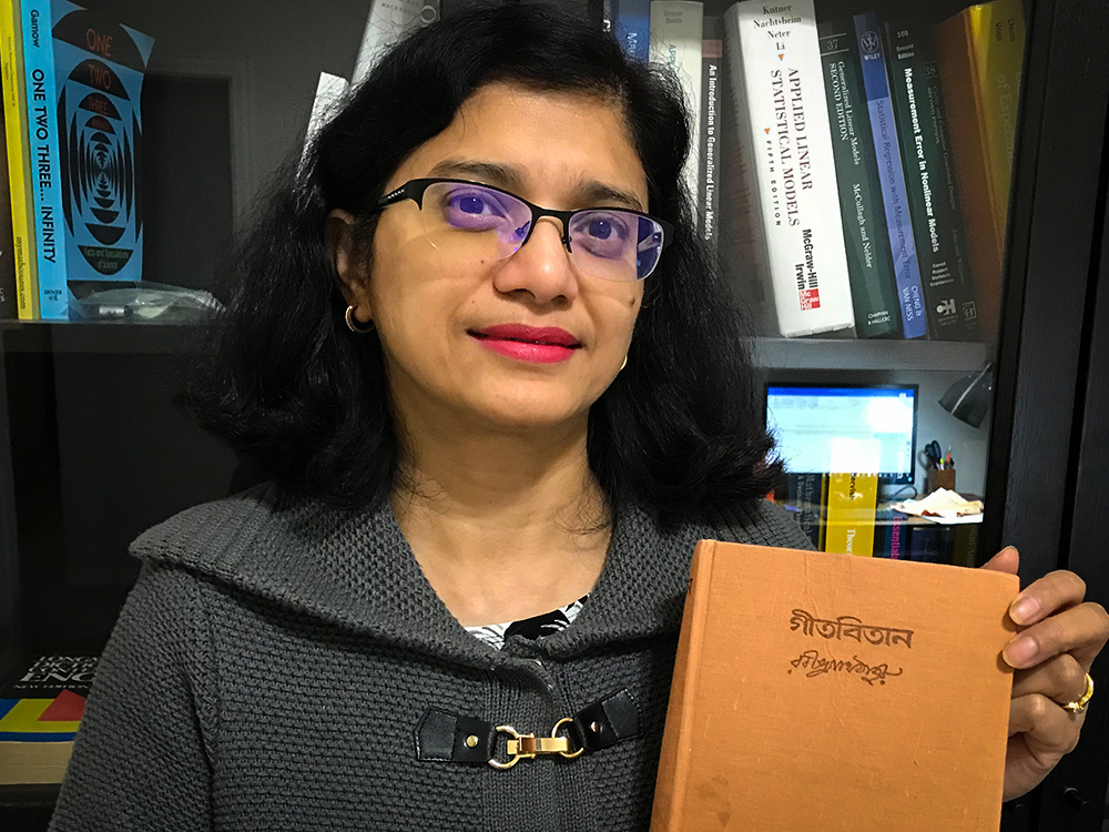 Woman holding book in front of bookshelf