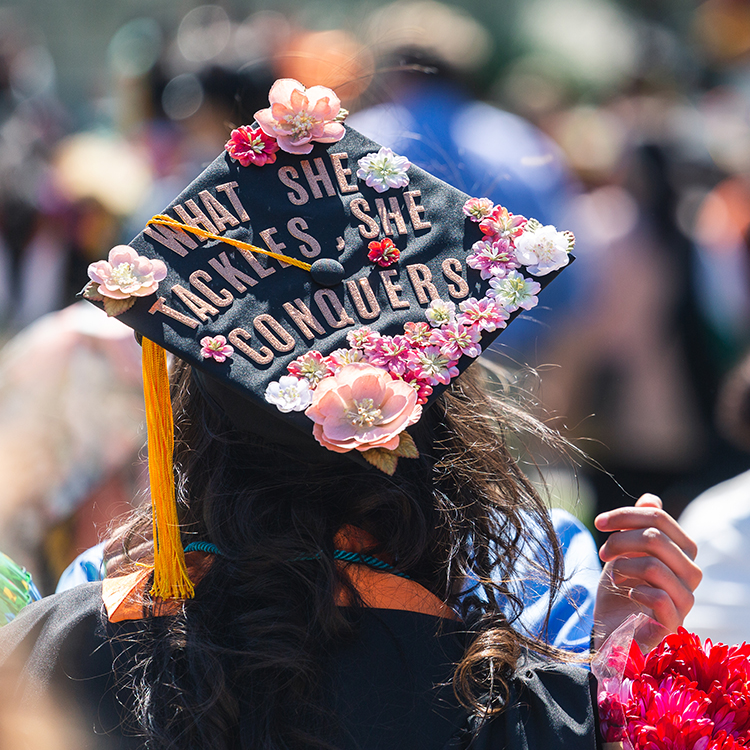 Cap that says what she tackles she conquers