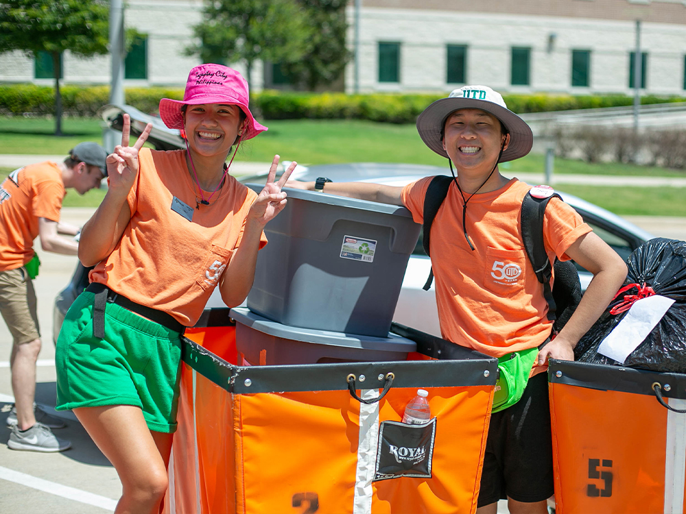 Student workers pause for a photo while loading up luggage in carts